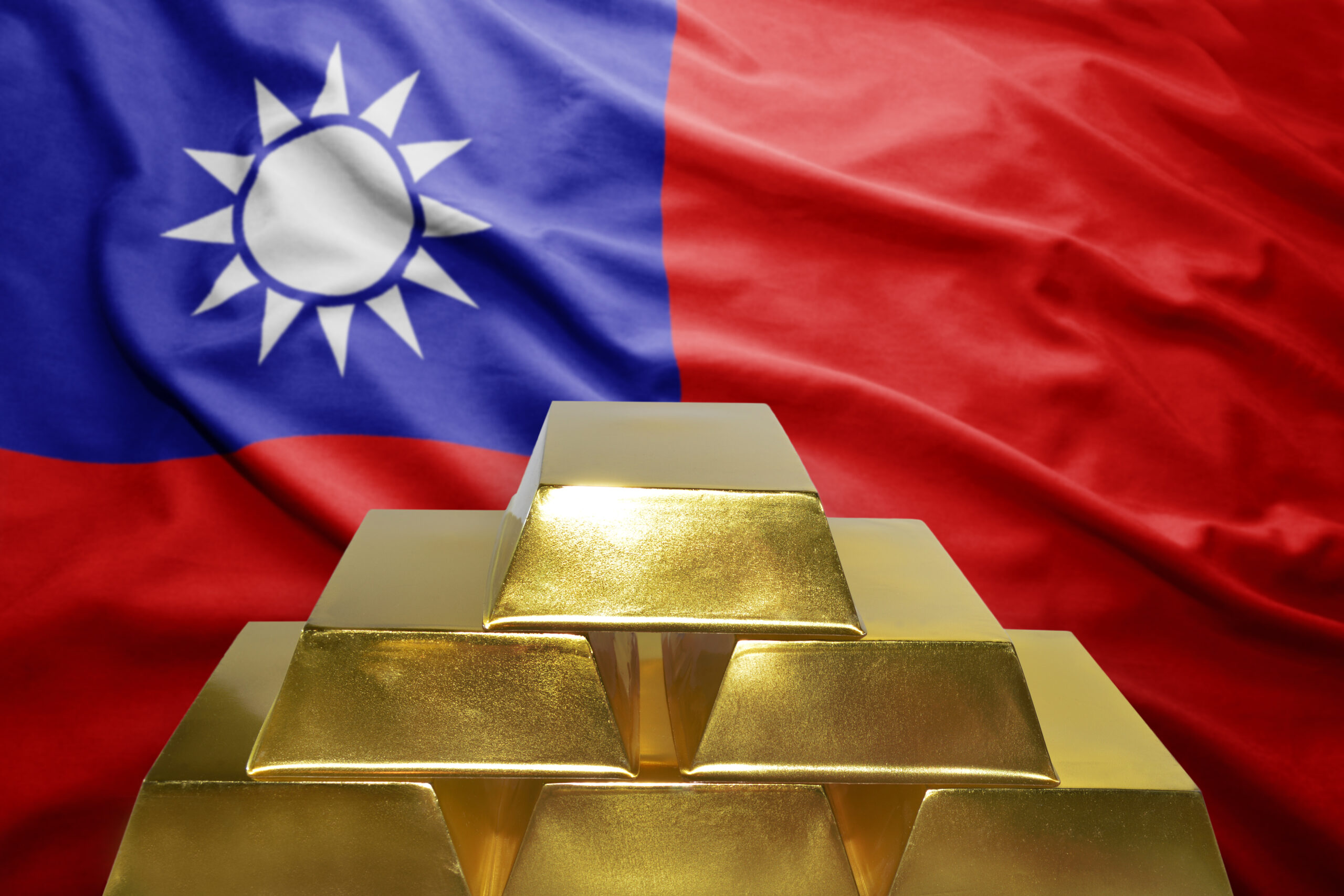 Goldbarren vor Taiwan-Flagge. Der Taiwan-Konflikt und die historische Rolle des Goldes darin.